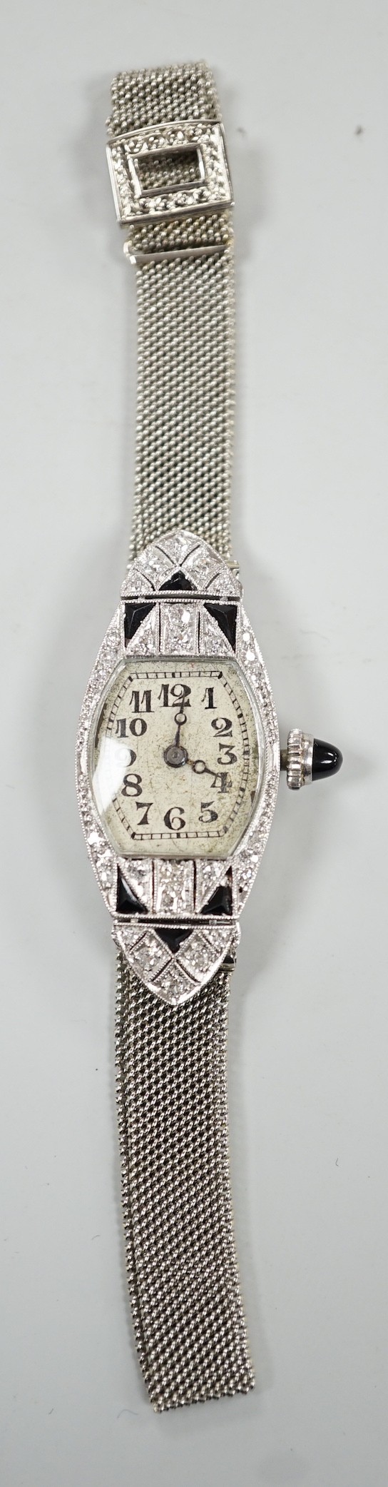 An Art Deco white metal (stamped platine) black onyx and diamond cluster set cocktail watch, on a 750 white mesh bracelet, approx. 16cm, gross weight 18.7 grams.